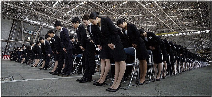 Uniformed employees bowing their heads to salute
