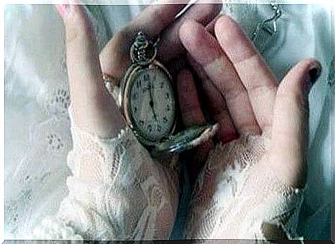 hands with a clock that marks the present
