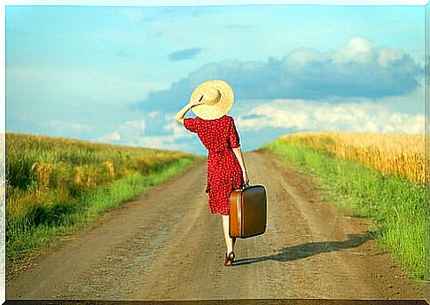 Woman with suitcase on a road